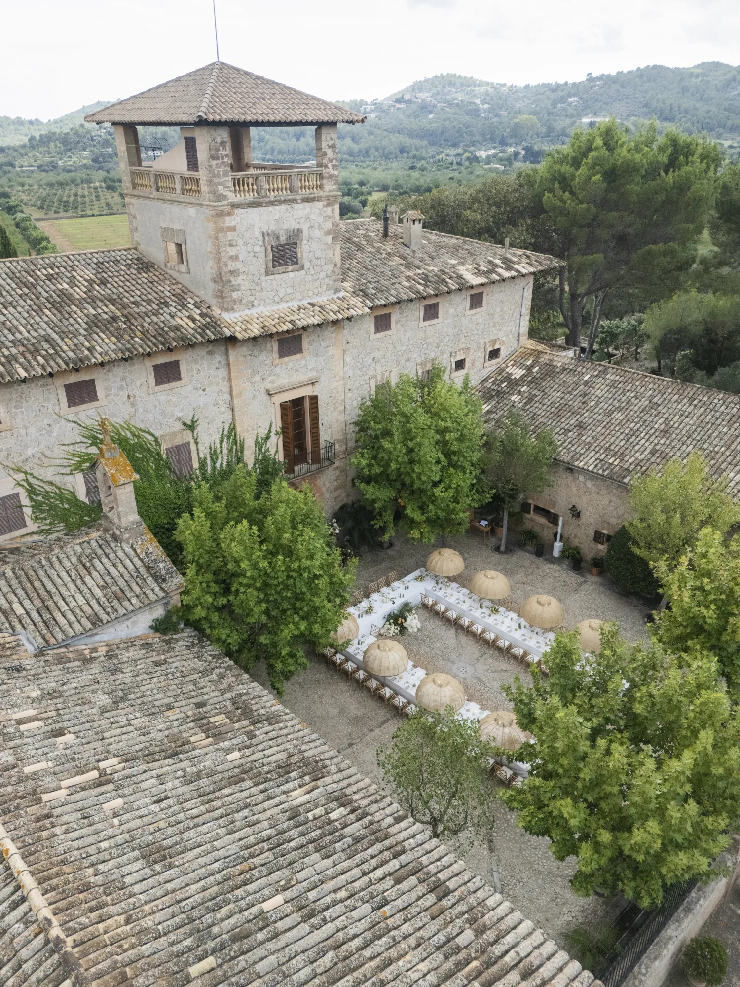 Aerial view of a stone villa with a tower and a garden reception