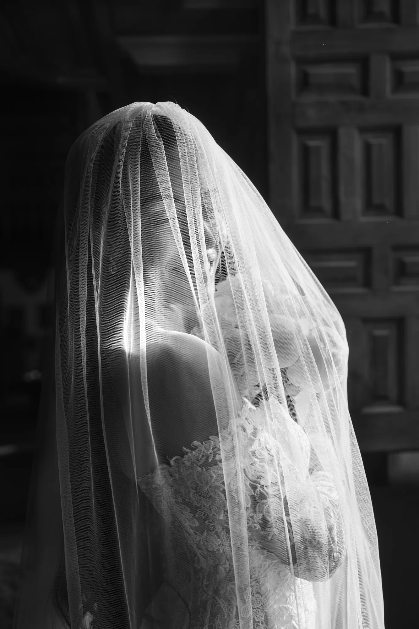 Black and white photo of a bride beneath her veil