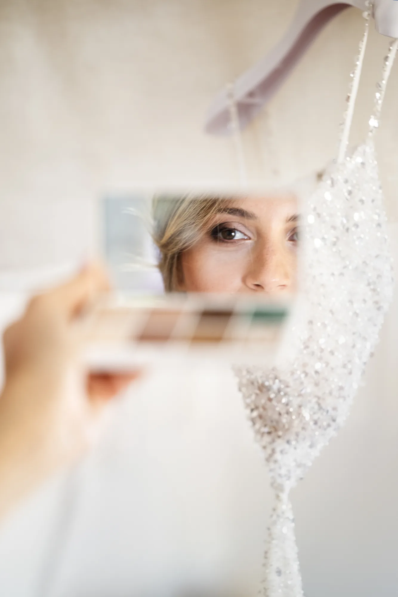 Bride's eye reflected in a makeup palette mirror