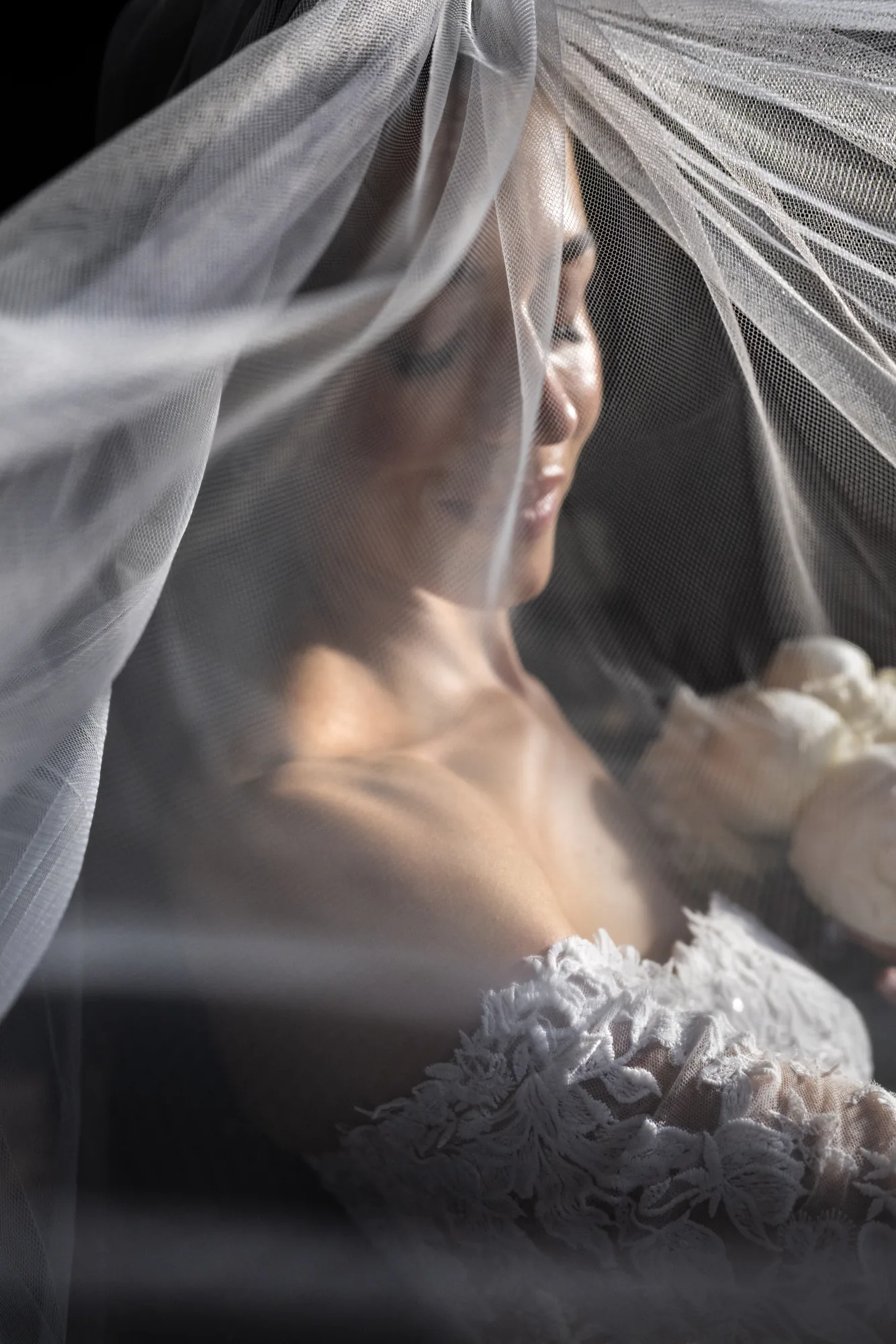 Bride smiling under a sheer veil