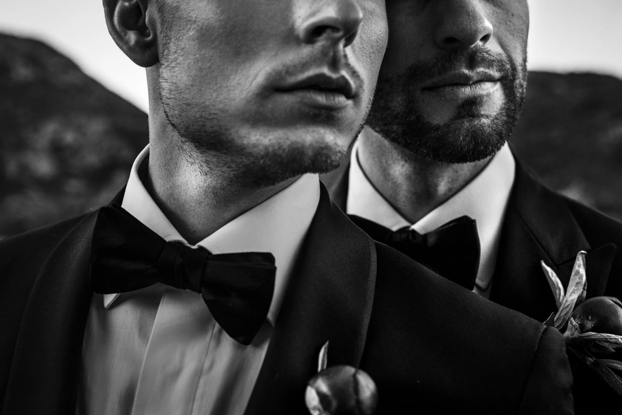 Close black and white portrait of two grooms in bow ties