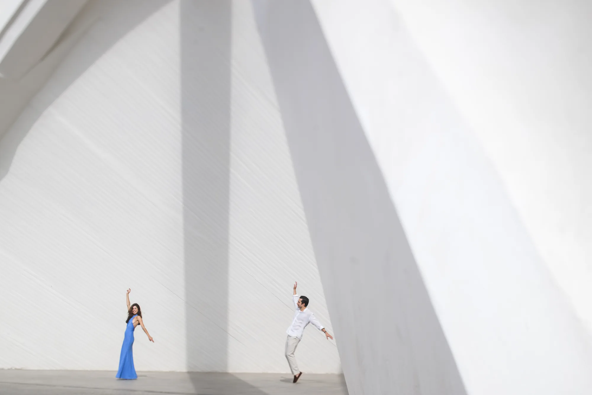 Couple dancing beneath sweeping white architecture