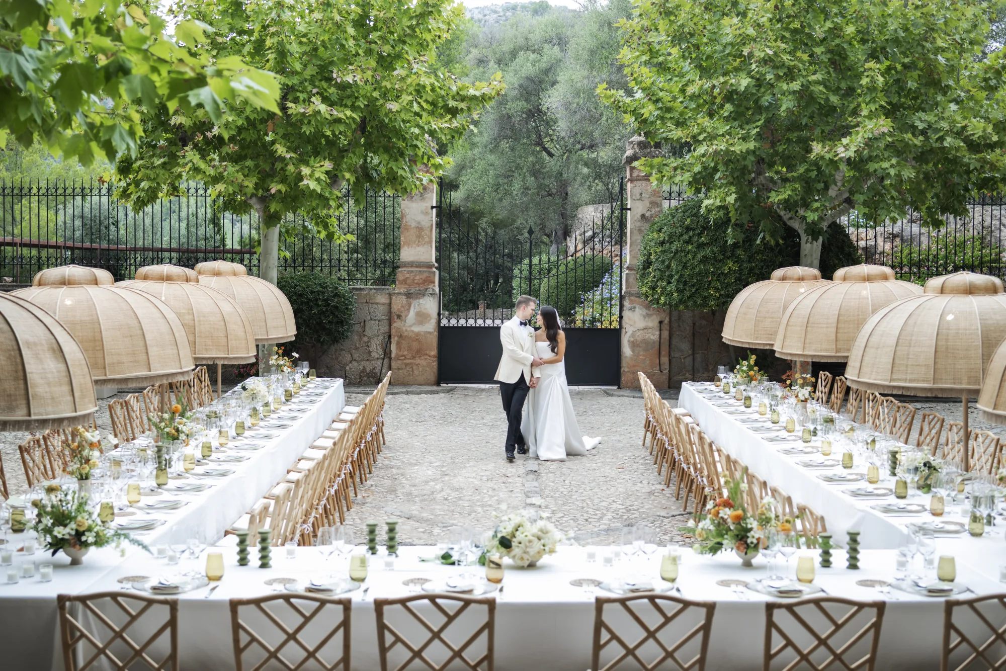 Couple kissing between long reception tables in a garden