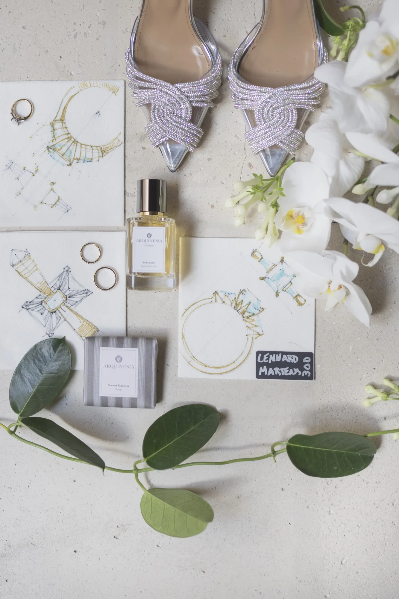 Flat lay of bridal shoes, perfume and jewellery