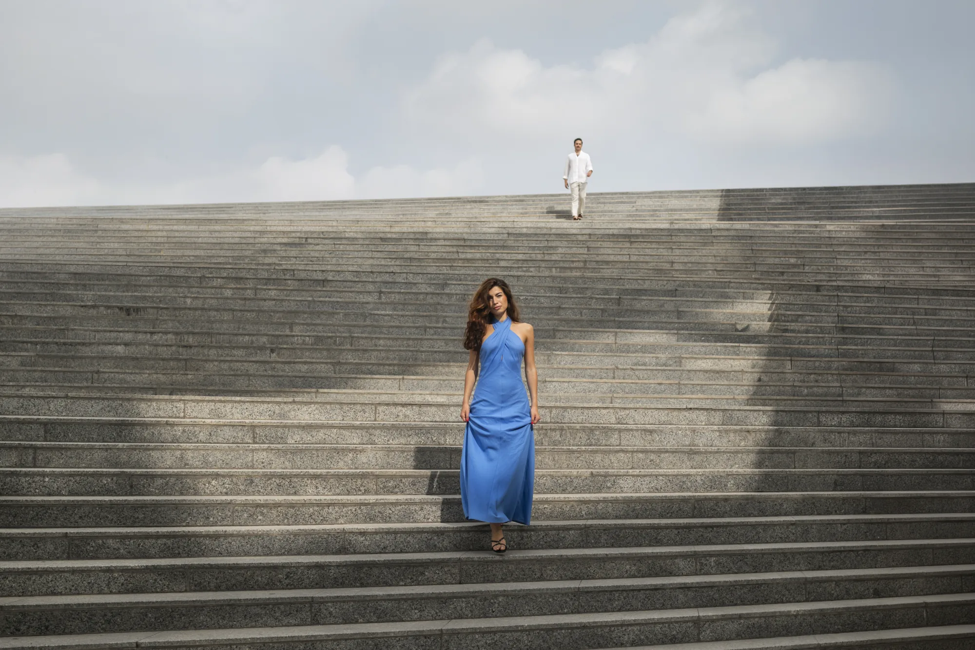 Guest in a blue gown on wide stone steps