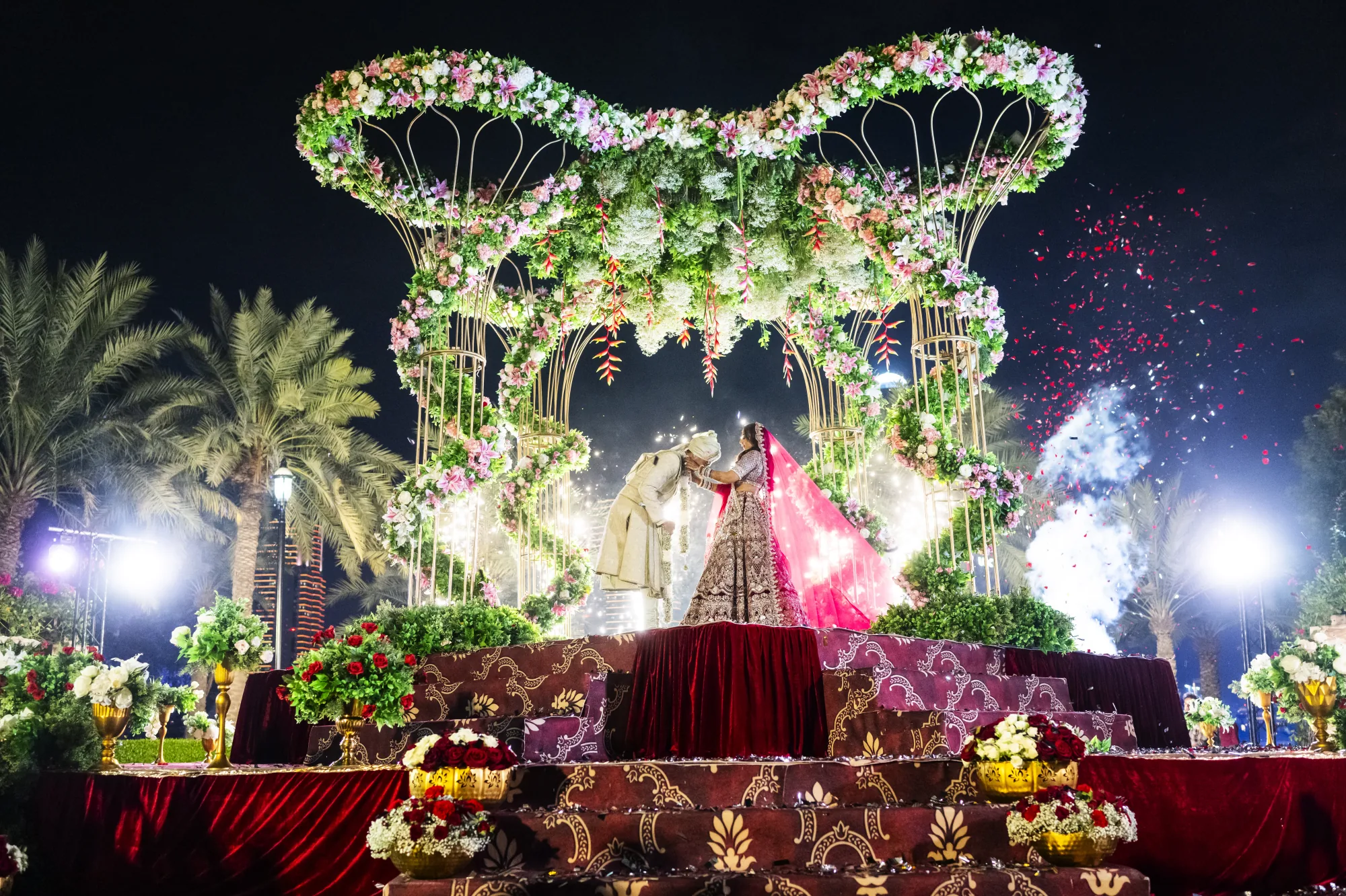 Indian wedding floral stage lit up at night