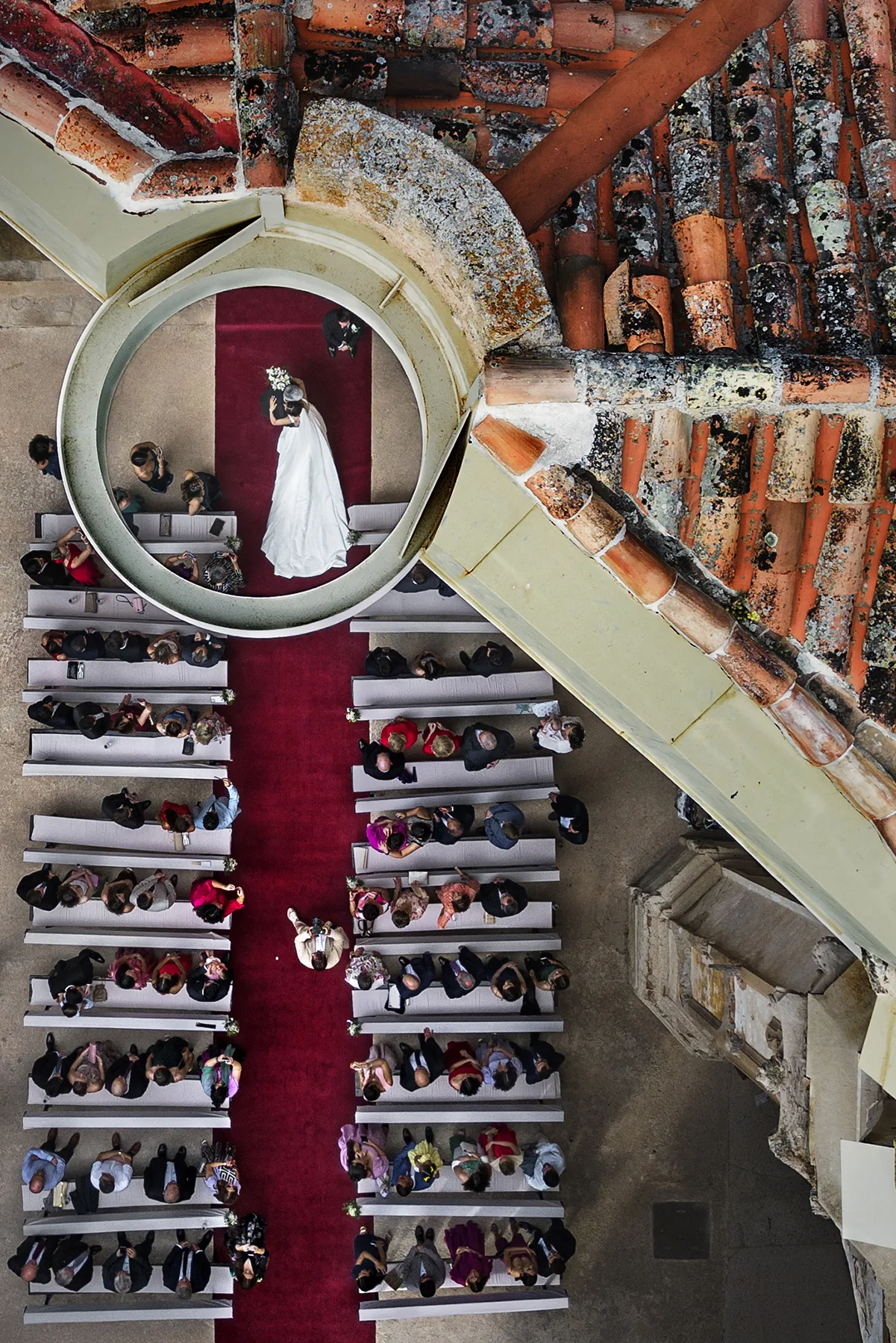 Overhead view of a ceremony along a red aisle