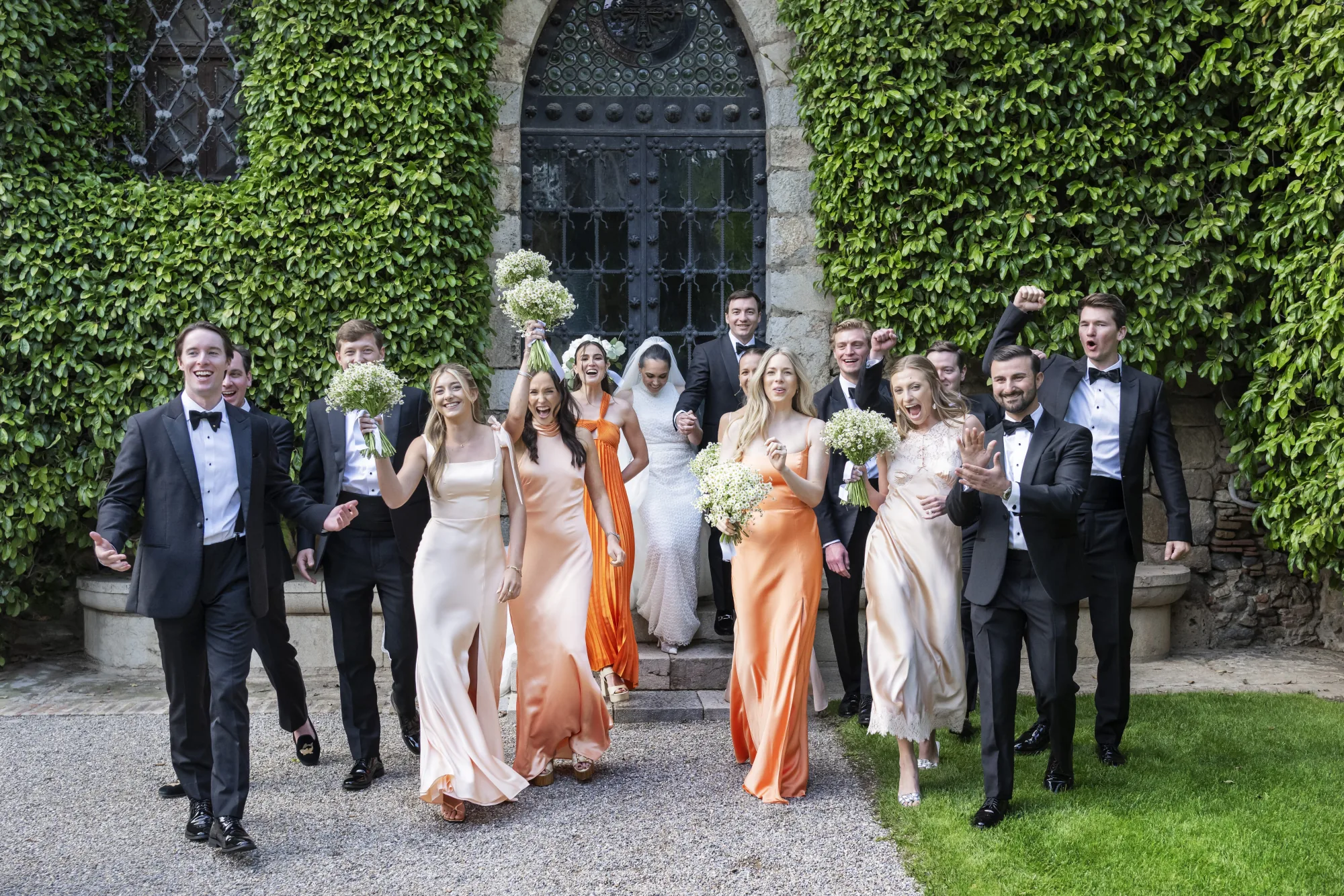 Wedding party walking out of an ivy-covered courtyard
